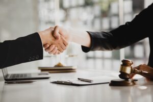 Lawyers shake hands with clients preparing to testify in an embezzlement case involving business partners. Represents hiring a lawyer for legal proceedings.