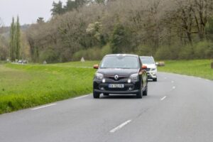 Renault car leading traffic on rural road