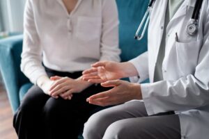 Doctor and patient discussing a health examination at the clinic office, close-up.