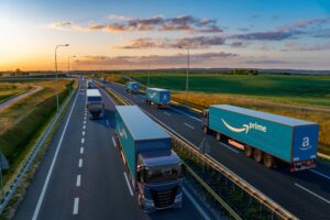 Trucks with Amazon Prime logos transporting semi-trailers on the highway